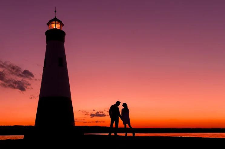Couple beside a lighthouse at sunset, photographed by Solas Studios